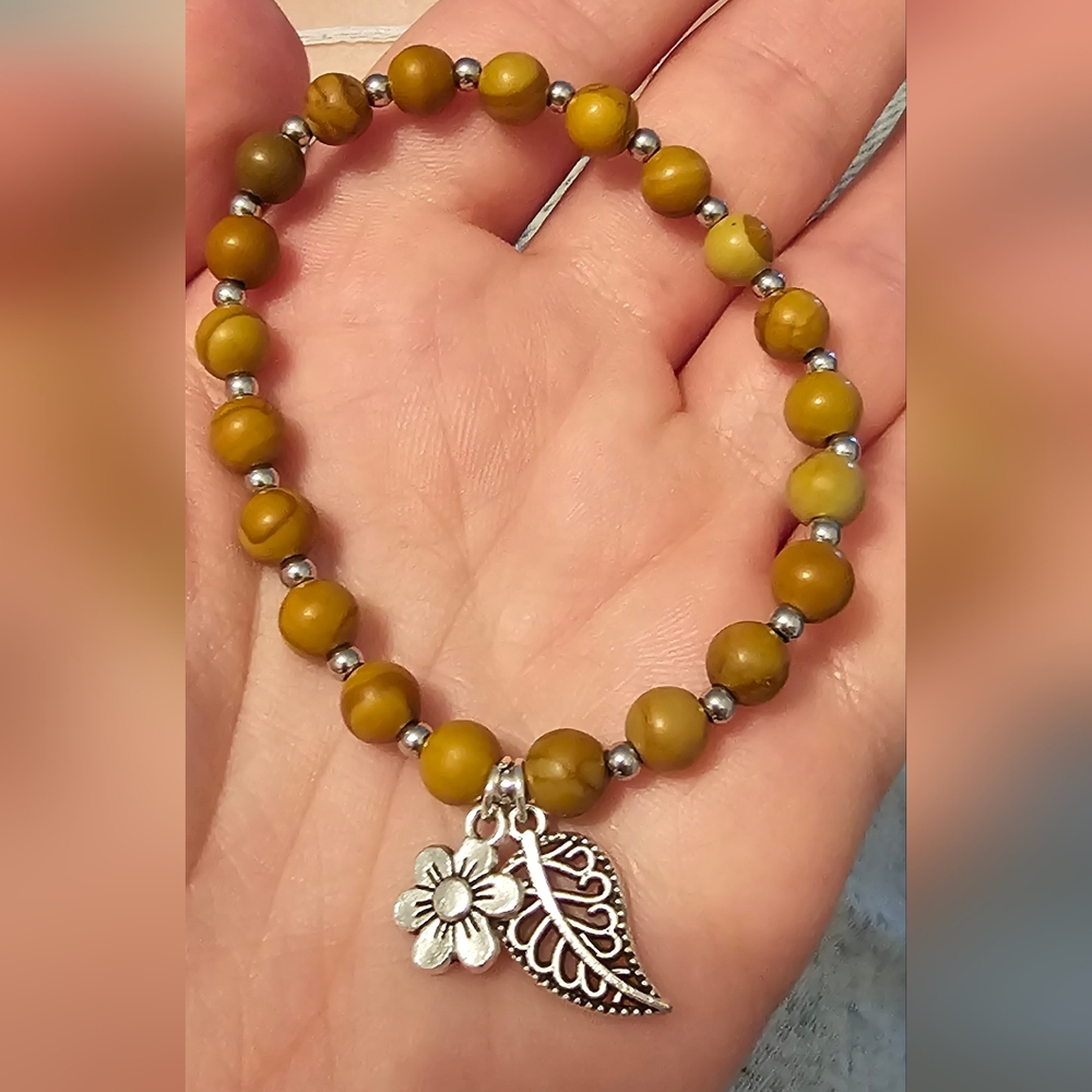Beaded bracelet with flower and leaf charm
